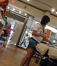 Peek up skirt, of young brunette in a shop