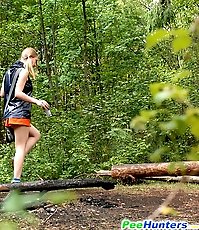 Girl stops to smoke a cig and take a leak in woods