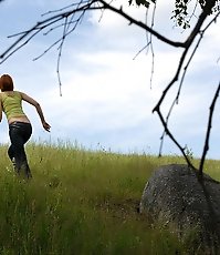 Babe tinkles on a rock in the middle of a field